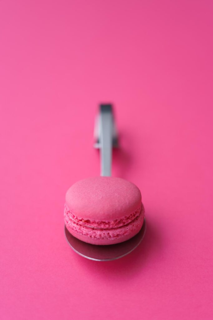 Pinkki väri huomion herättäjänä, kuvassa pinkki macarons pinkillä taustalla. Valokuva.