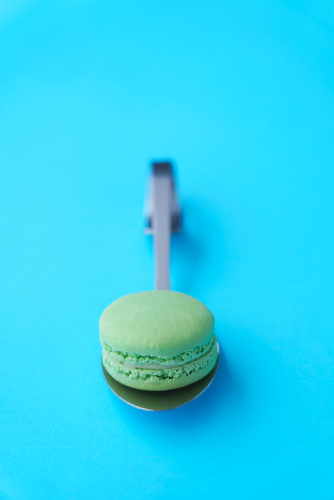 Värillä on väliä, vihreä macarons turkoosilla taustalla.